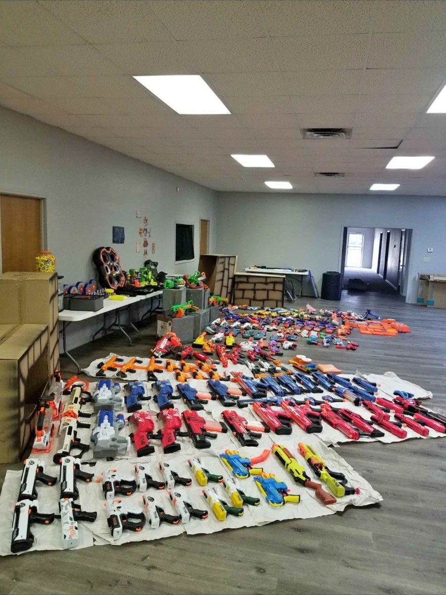 Nerf blasters sorted in long rows across the floor of the Kinetic Command staging room